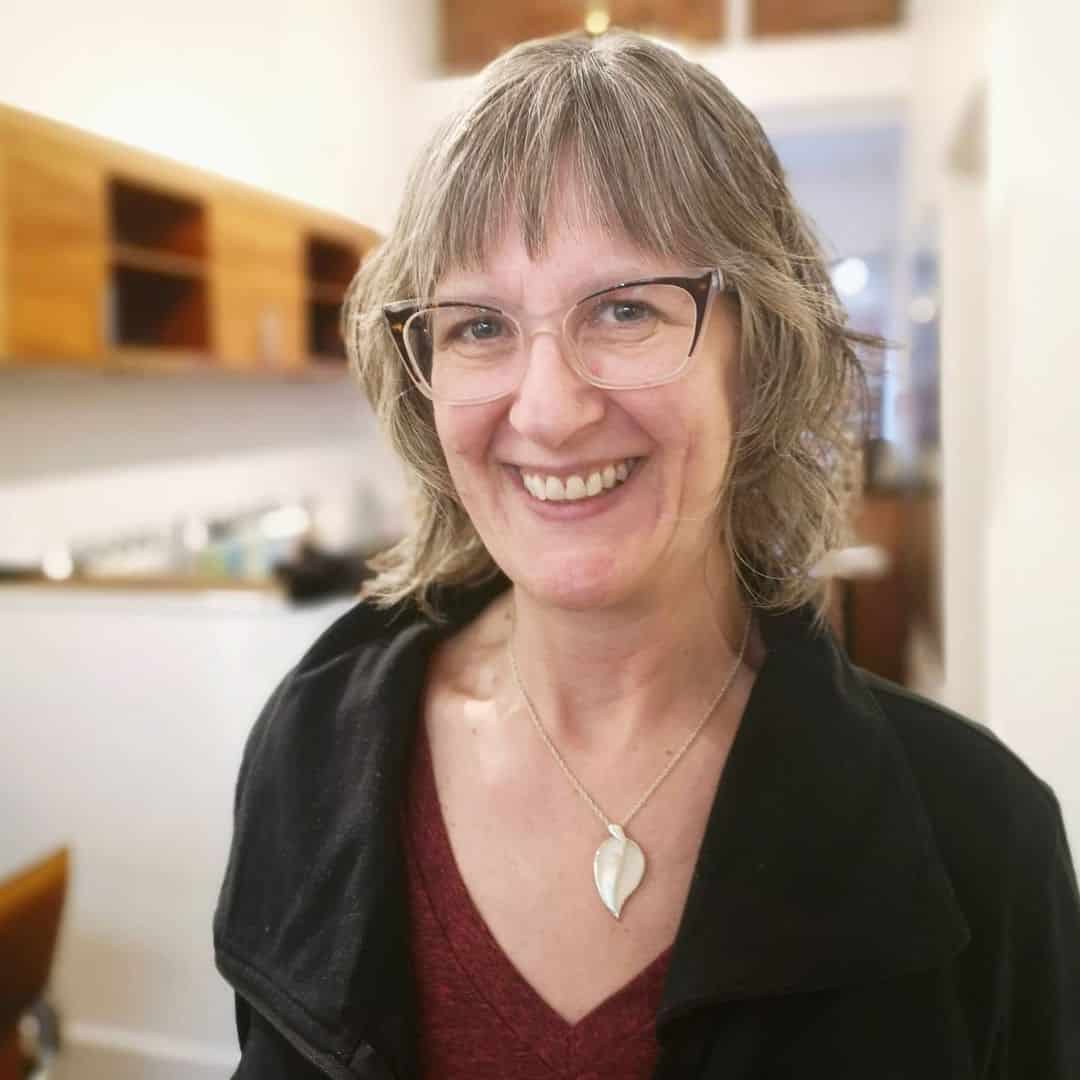 face framing cut for older women with glasses and thin hair