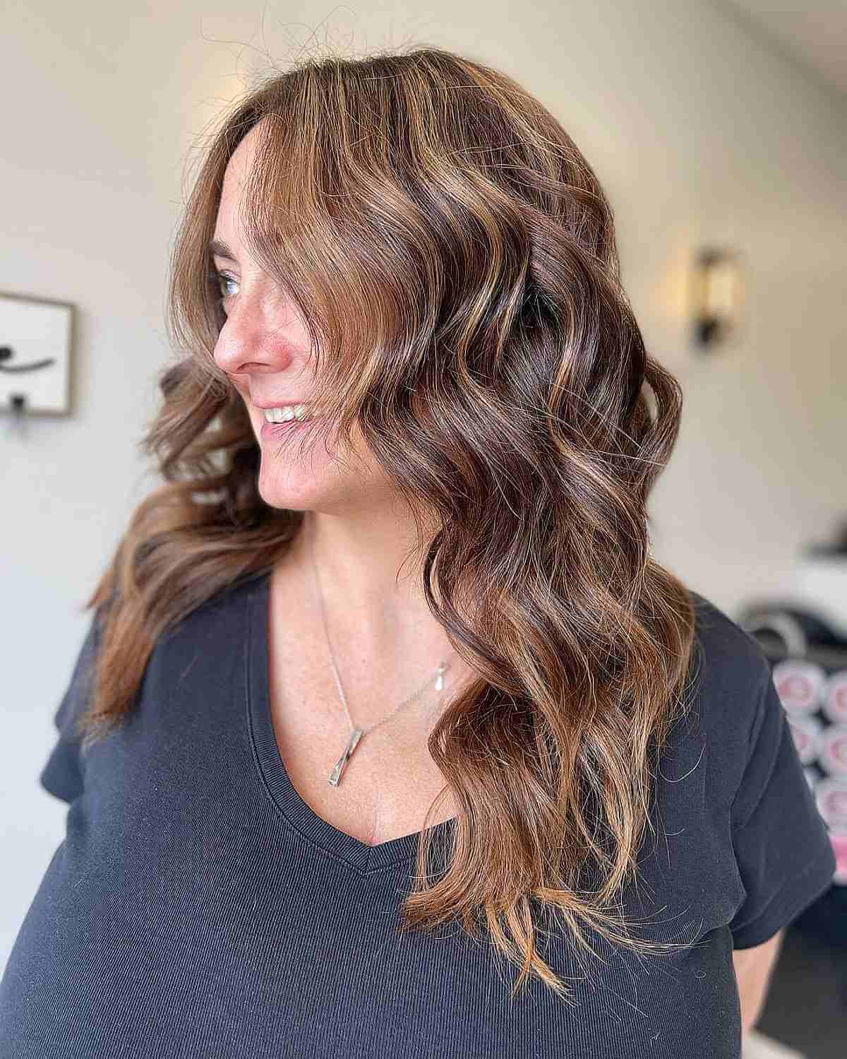 beach wavy brown hair with subtle highlights for woman over 40 years old