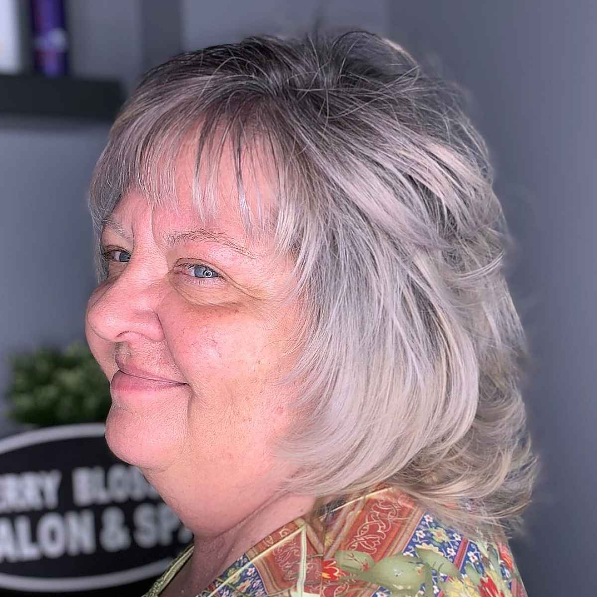 layered shaggy haircut with wispy bangs for round faces over 60