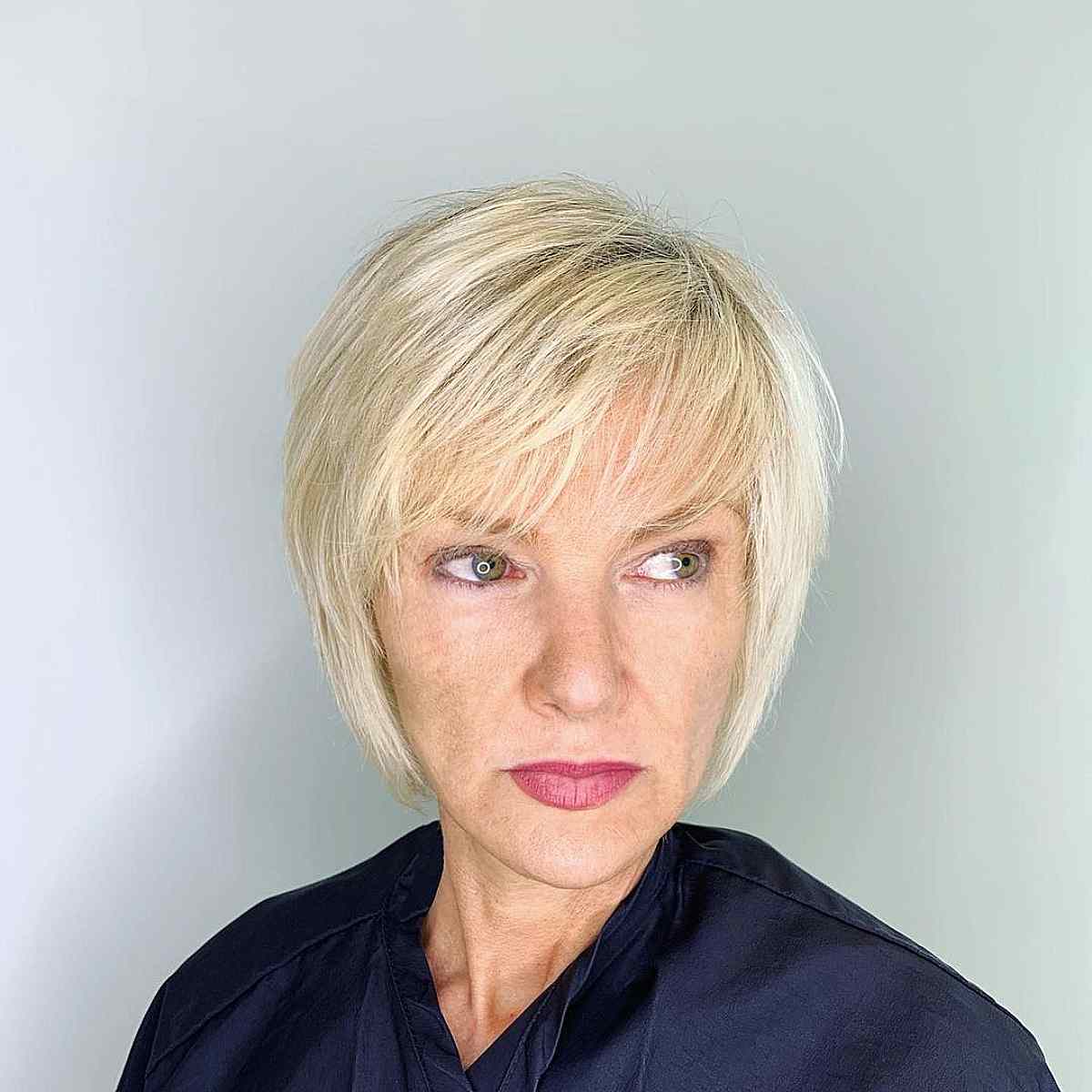 short wispy blonde bob with side swept bangs for women 40 and up